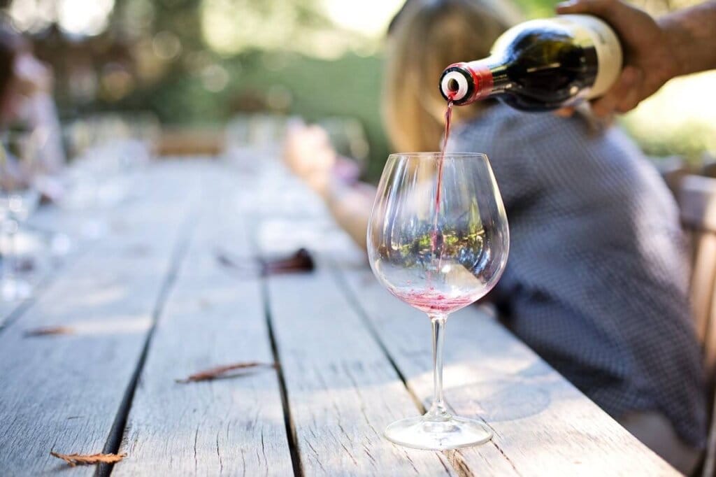 Garrafa aberta com vinho na taça