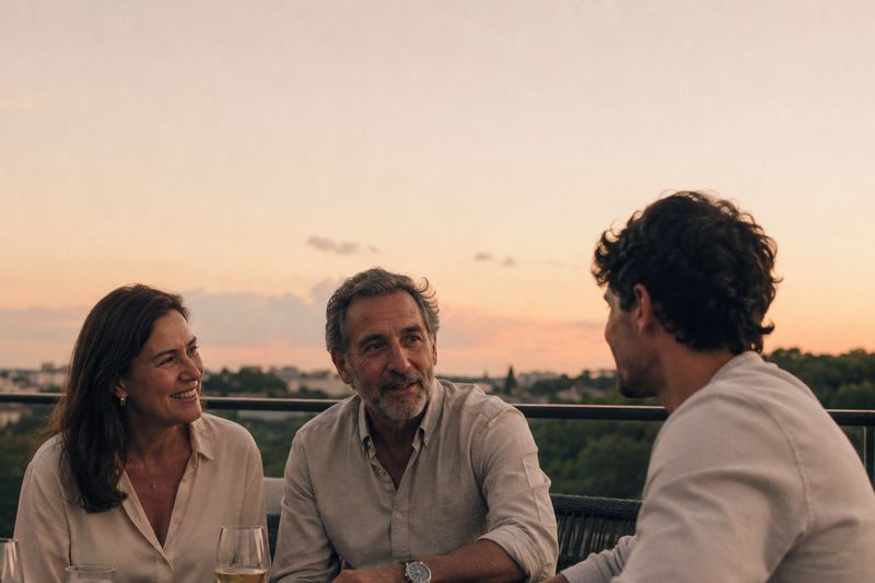 Casal conversa com o filho adulto em um terraço ao entardecer